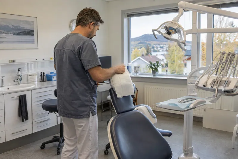 Tannlege som klargjør en behandlingsstol i en tannklinikk.
